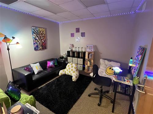 room filled with couch, pillows, lamps, and activity tables